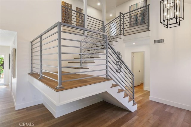 13621 Fairmont Way, Tustin, CA 92780 - stairs featuring a towering ceiling, baseboards, wood finished floors, and a chandelier