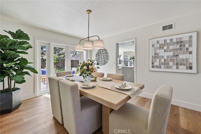 13621 Fairmont Way, Tustin, CA 92780 - dining area with light wood finished floors, baseboards, and a textured ceiling