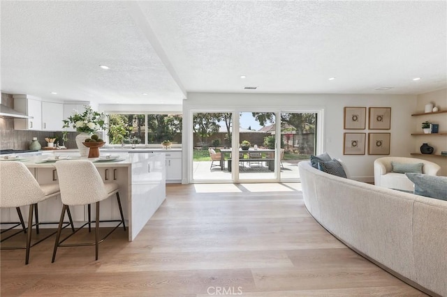 13621 Fairmont Way, Tustin, CA 92780 - living area featuring healthy amount of natural light, recessed lighting, a textured ceiling, and light wood-type flooring