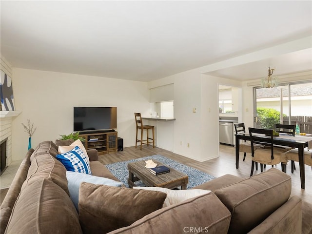 22652 Nadine Cir Unit A, Torrance, CA 90505 - living area featuring light wood-style floors, a fireplace, and a chandelier