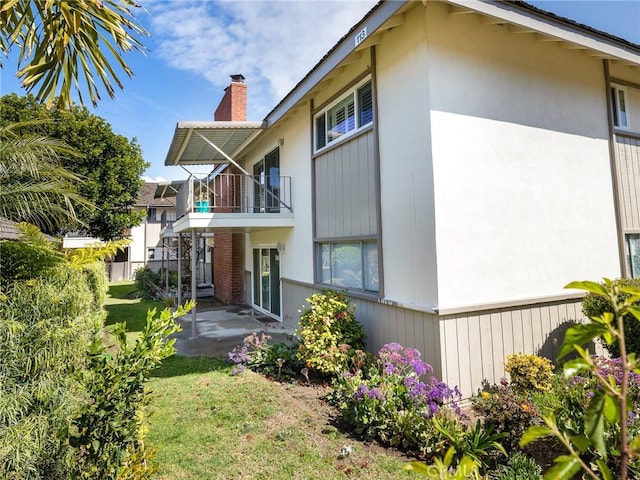 22652 Nadine Cir Unit A, Torrance, CA 90505 - back of property with a balcony, a chimney, stucco siding, a patio, and a lawn