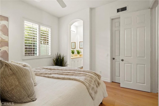 12165 Ojeda Ct, Tustin, CA 92782 - bedroom featuring light wood finished floors, arched walkways, ensuite bathroom, a ceiling fan, and baseboards