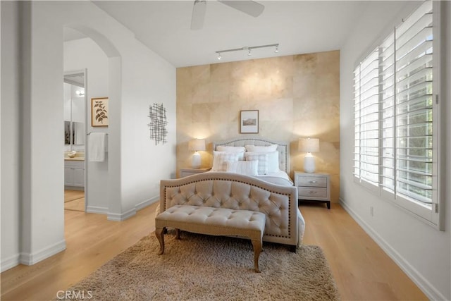 12165 Ojeda Ct, Tustin, CA 92782 - bedroom with multiple windows, wood finished floors, arched walkways, and baseboards