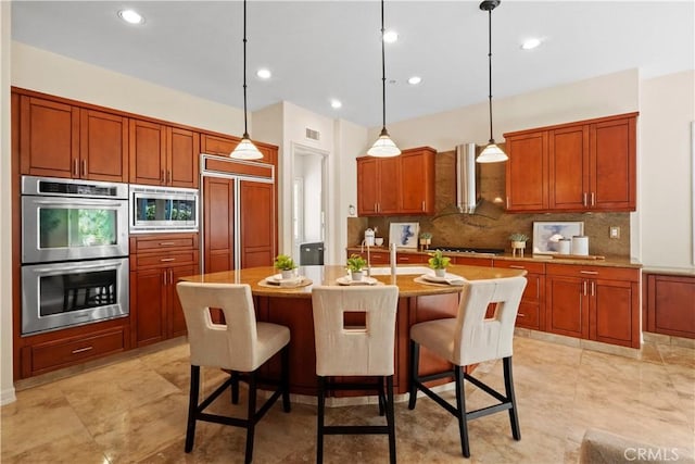 12165 Ojeda Ct, Tustin, CA 92782 - kitchen with built in appliances, wall chimney exhaust hood, backsplash, brown cabinets, and pendant lighting