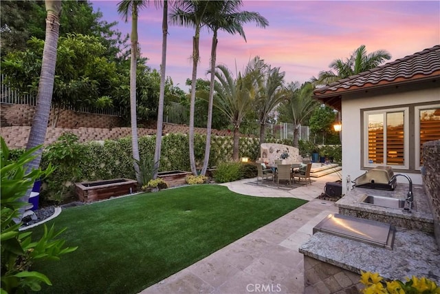 12165 Ojeda Ct, Tustin, CA 92782 - yard at dusk featuring a patio, an outdoor kitchen, and a sink