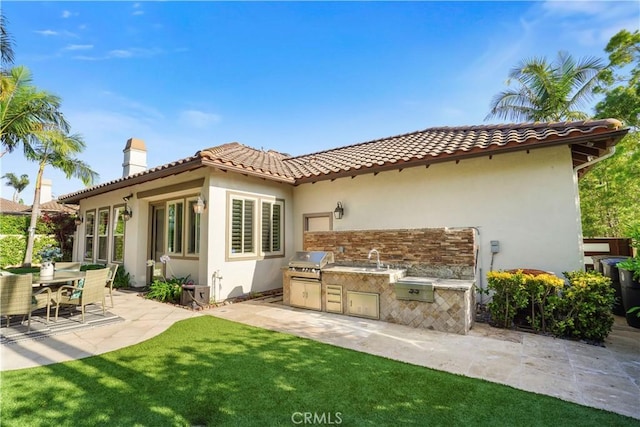 12165 Ojeda Ct, Tustin, CA 92782 - back of property with area for grilling, stucco siding, a patio area, a chimney, and a yard