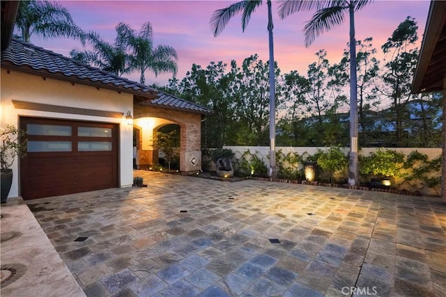 12165 Ojeda Ct, Tustin, CA 92782 - view of patio featuring decorative driveway and a garage