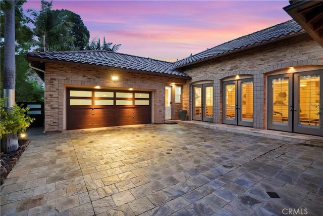 12165 Ojeda Ct, Tustin, CA 92782 - view of front of home with french doors, a tiled roof, a garage, and decorative driveway