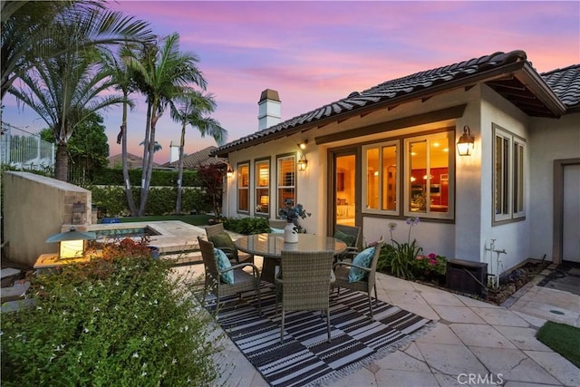 12165 Ojeda Ct, Tustin, CA 92782 - back of house with a chimney, a patio area, stucco siding, a tiled roof, and outdoor dining area