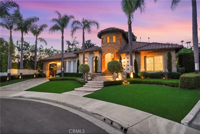 12165 Ojeda Ct, Tustin, CA 92782 - mediterranean / spanish-style house with a tiled roof, driveway, a yard, stone siding, and stucco siding