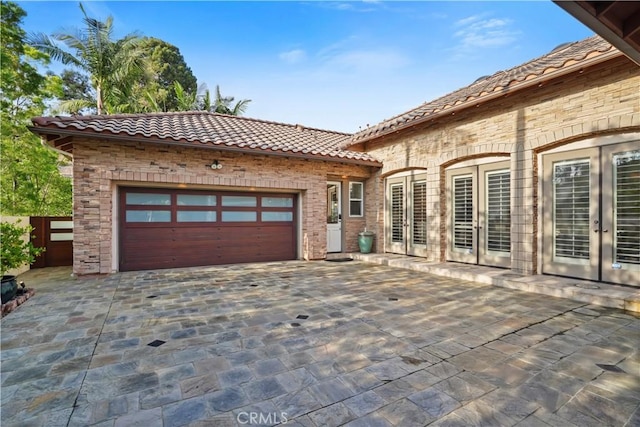 12165 Ojeda Ct, Tustin, CA 92782 - view of patio / terrace featuring french doors, decorative driveway, and an attached garage