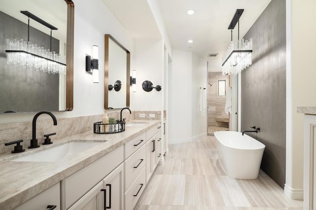 238 Date Ave, Carlsbad, CA 92008 - full bathroom with double vanity, a tile shower, a freestanding bath, a chandelier, and baseboards