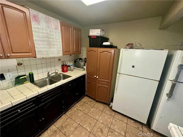 17406 Renault St, La Puente, CA 91744 - kitchen featuring tile counters, a sink, freestanding refrigerator, light tile patterned flooring, and backsplash