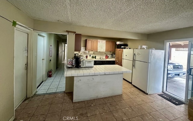 17406 Renault St, La Puente, CA 91744 - kitchen featuring white appliances, tile countertops, a textured ceiling, backsplash, and light tile patterned floors
