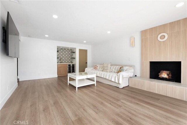 3550 Goldenrod Cir, Seal Beach, CA 90740 - living area with light wood finished floors, a large fireplace, recessed lighting, a dry bar, and baseboards