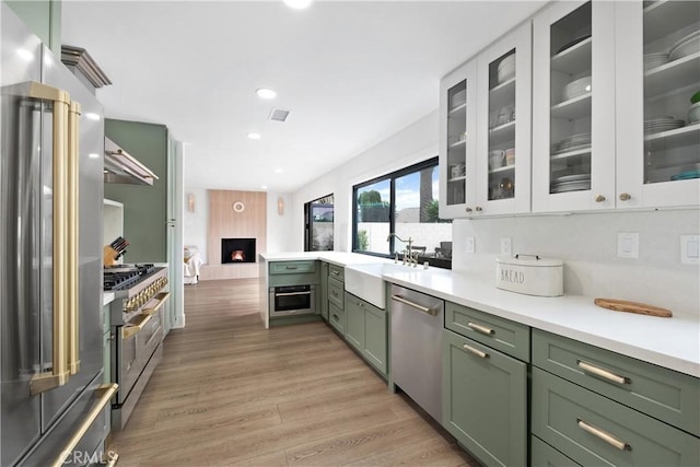 3550 Goldenrod Cir, Seal Beach, CA 90740 - kitchen with green cabinetry, high end appliances, a sink, light countertops, and recessed lighting