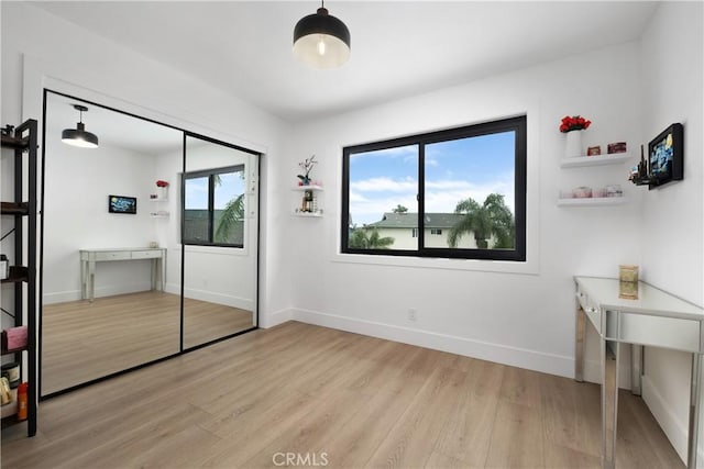 3550 Goldenrod Cir, Seal Beach, CA 90740 - unfurnished bedroom with light wood finished floors, multiple windows, baseboards, and a closet