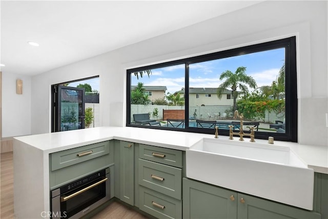 3550 Goldenrod Cir, Seal Beach, CA 90740 - kitchen featuring green cabinetry, a sink, light countertops, stainless steel oven, and recessed lighting