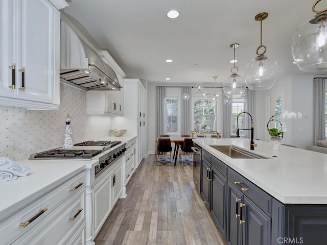 1 Lennox Ct, Ladera Ranch, CA 92694 - kitchen with white cabinetry, a sink, wall chimney range hood, light wood finished floors, and light countertops