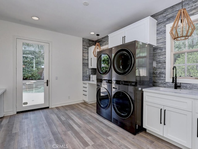 1 Lennox Ct, Ladera Ranch, CA 92694 - laundry room featuring stacked washer and clothes dryer, cabinet space, light wood-type flooring, and recessed lighting