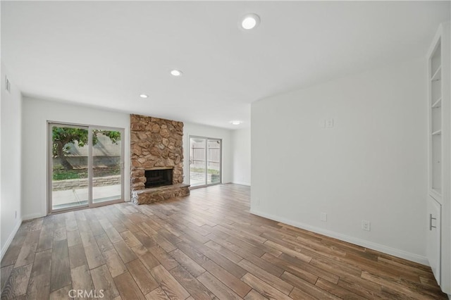 427 W Northridge Ave, Glendora, CA 91741 - unfurnished living room featuring wood finished floors, plenty of natural light, baseboards, recessed lighting, and a stone fireplace