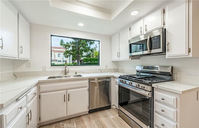 611 W 1st St Unit 101, Santa Ana, CA 92701 - kitchen with appliances with stainless steel finishes, a sink, recessed lighting, a tray ceiling, and crown molding