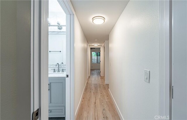 611 W 1st St Unit 101, Santa Ana, CA 92701 - corridor featuring light wood finished floors, a sink, and baseboards
