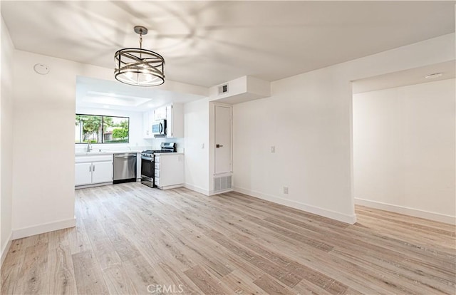611 W 1st St Unit 101, Santa Ana, CA 92701 - unfurnished living room featuring light wood finished floors, baseboards, and a sink