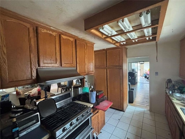 108 Leoma Ln, Chula Vista, CA 91911 - kitchen featuring stainless steel range with gas cooktop, brown cabinets, light tile patterned flooring, and ventilation hood