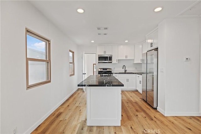 10931 S Burl Ave, Inglewood, CA 90304 - kitchen with stainless steel appliances, white cabinets, dark countertops, a center island, and recessed lighting