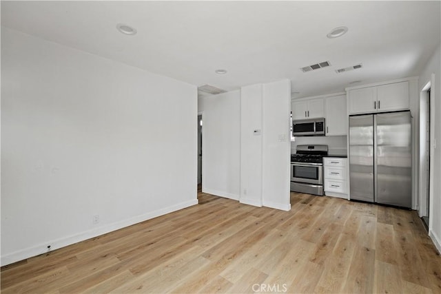 10931 S Burl Ave, Inglewood, CA 90304 - kitchen with stainless steel appliances, light wood-type flooring, white cabinetry, recessed lighting, and dark countertops