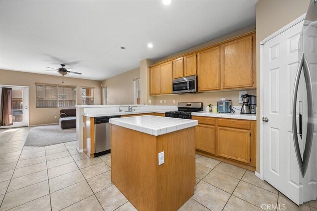 3762 Almansa Way, Perris, CA 92571 - kitchen with stainless steel appliances, tile counters, a peninsula, light tile patterned floors, and recessed lighting