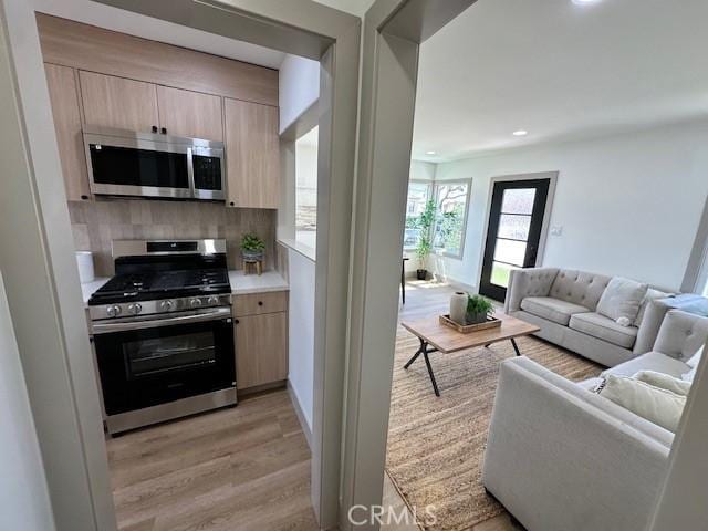 2510 Termino Ave, Long Beach, CA 90815 - kitchen featuring appliances with stainless steel finishes, light brown cabinetry, light wood-style floors, light countertops, and open floor plan