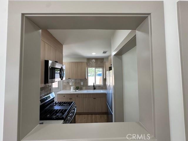 2510 Termino Ave, Long Beach, CA 90815 - kitchen with stainless steel appliances, light brown cabinetry, light countertops, and backsplash