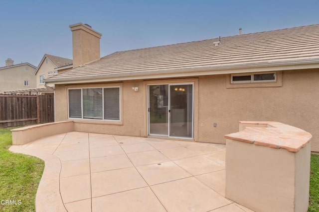 1724 Hilaria St, Oxnard, CA 93030 - rear view of property featuring a tile roof, a patio area, a chimney, and stucco siding