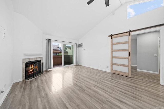 2920 Briarwood Rd Unit G12, Bonita, CA 91902 - unfurnished living room with a barn door, a ceiling fan, a fireplace, wood finished floors, and high vaulted ceiling
