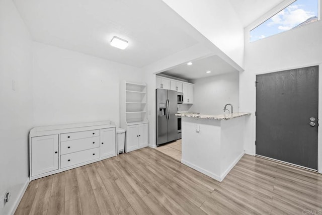 2920 Briarwood Rd Unit G12, Bonita, CA 91902 - kitchen featuring stainless steel appliances, white cabinets, a peninsula, light wood-style floors, and light stone counters