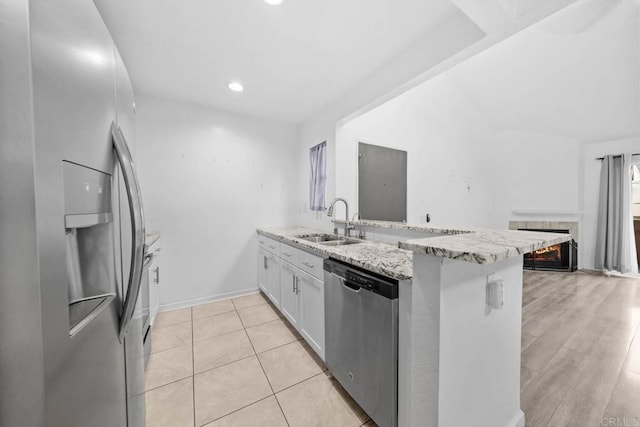 2920 Briarwood Rd Unit G12, Bonita, CA 91902 - kitchen featuring stainless steel appliances, a sink, a peninsula, white cabinetry, and light stone countertops