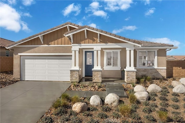 13897 Mesa View Dr, Victorville, CA 92392 - craftsman-style home featuring stone siding, a tile roof, a garage, driveway, and stucco siding