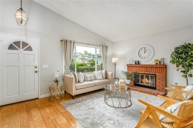 366 Elderberry St, La Verne, CA 91750 - living room featuring a textured ceiling, lofted ceiling, wood finished floors, and a fireplace