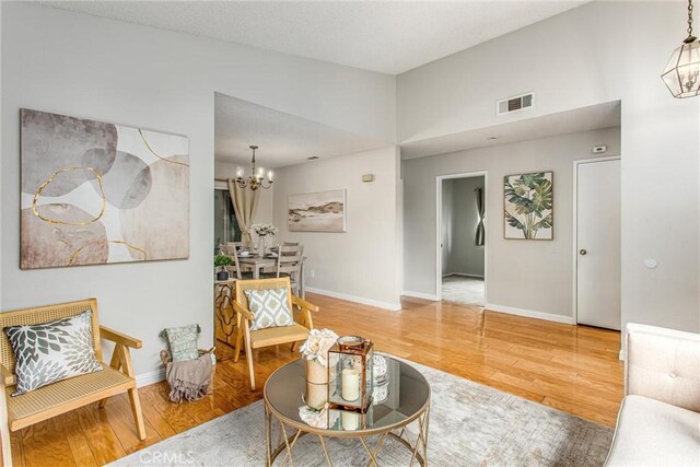 366 Elderberry St, La Verne, CA 91750 - living room featuring a chandelier, wood finished floors, baseboards, and vaulted ceiling