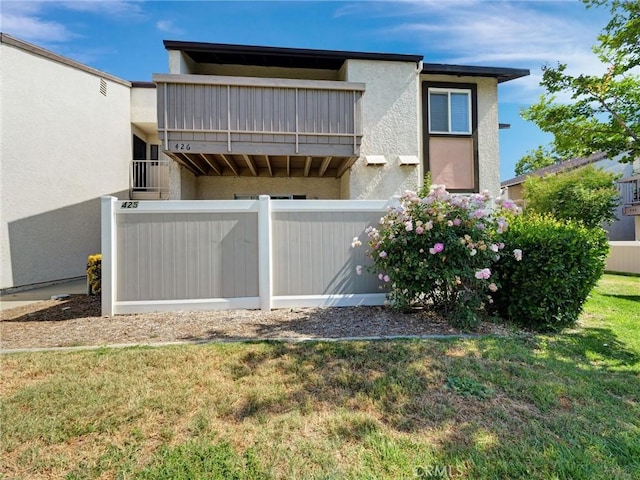 8990 19th St Unit 426, Rancho Cucamonga, CA 91701 - back of property featuring a yard, stucco siding, and a balcony