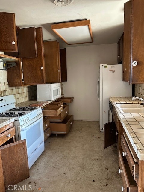 28450 6th St, Temecula, CA 92590 - kitchen with tile countertops, white appliances, a sink, backsplash, and dark brown cabinets