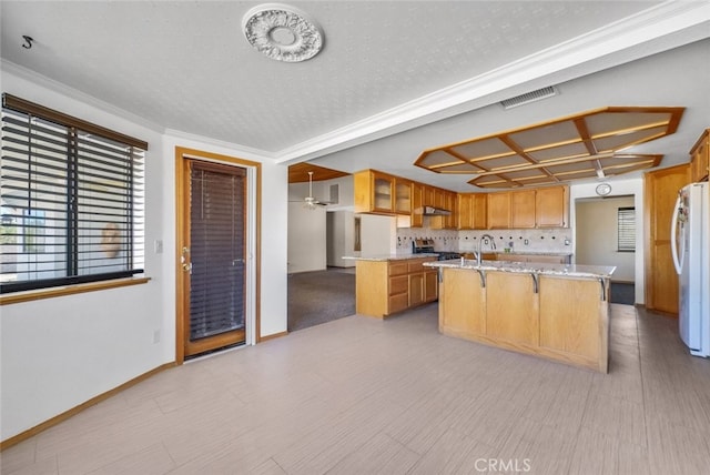 16635 Wintun Rd, Apple Valley, CA 92307 - kitchen featuring freestanding refrigerator, an island with sink, stainless steel range oven, glass insert cabinets, and ventilation hood