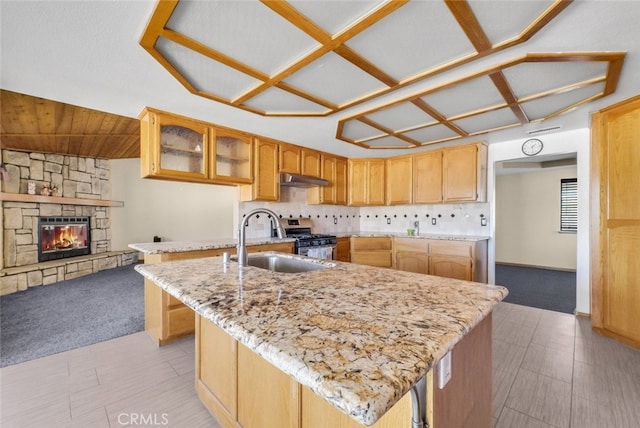 16635 Wintun Rd, Apple Valley, CA 92307 - kitchen featuring a sink, light colored carpet, stainless steel range with gas stovetop, light stone countertops, and glass insert cabinets