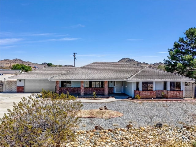 16635 Wintun Rd, Apple Valley, CA 92307 - ranch-style house featuring an attached garage, driveway, brick siding, and a porch
