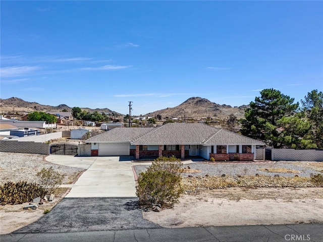 16635 Wintun Rd, Apple Valley, CA 92307 - ranch-style home featuring a mountain view, an attached garage, driveway, brick siding, and a tiled roof