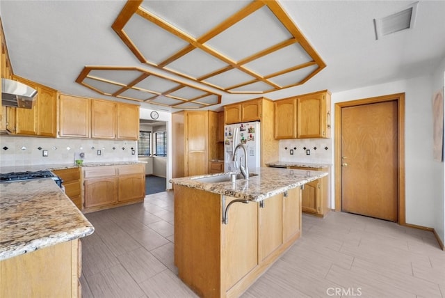 16635 Wintun Rd, Apple Valley, CA 92307 - kitchen featuring a sink, freestanding refrigerator, backsplash, and an island with sink
