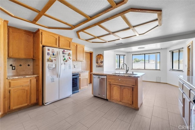 16635 Wintun Rd, Apple Valley, CA 92307 - kitchen featuring dishwasher, white fridge with ice dispenser, a sink, and decorative backsplash