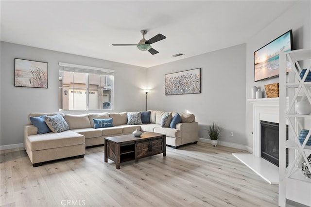 341 W Pebble Creek Ln, Orange, CA 92865 - living area with light wood-style floors, ceiling fan, a glass covered fireplace, and baseboards